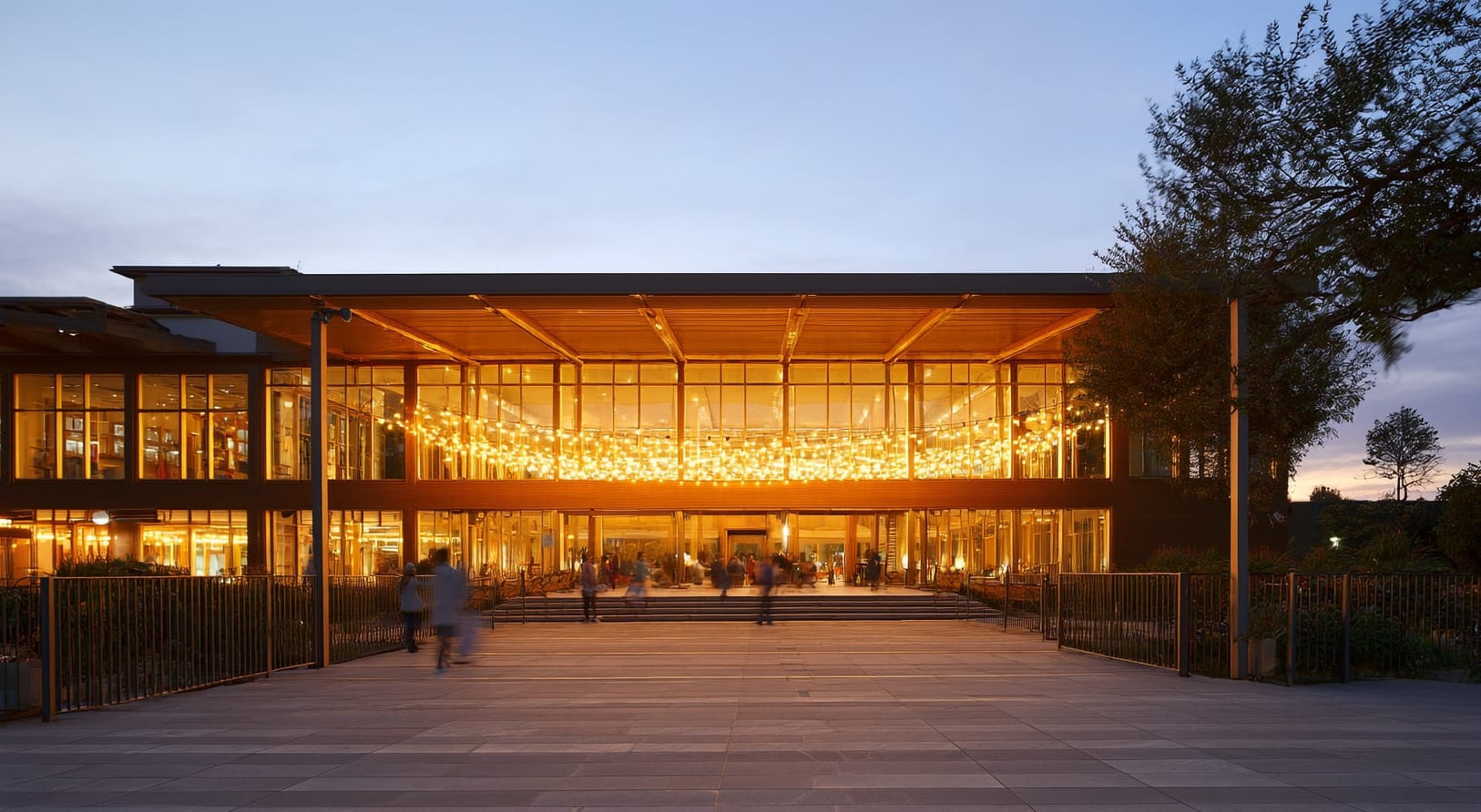 A welcoming community centre glowing with warm light at dusk